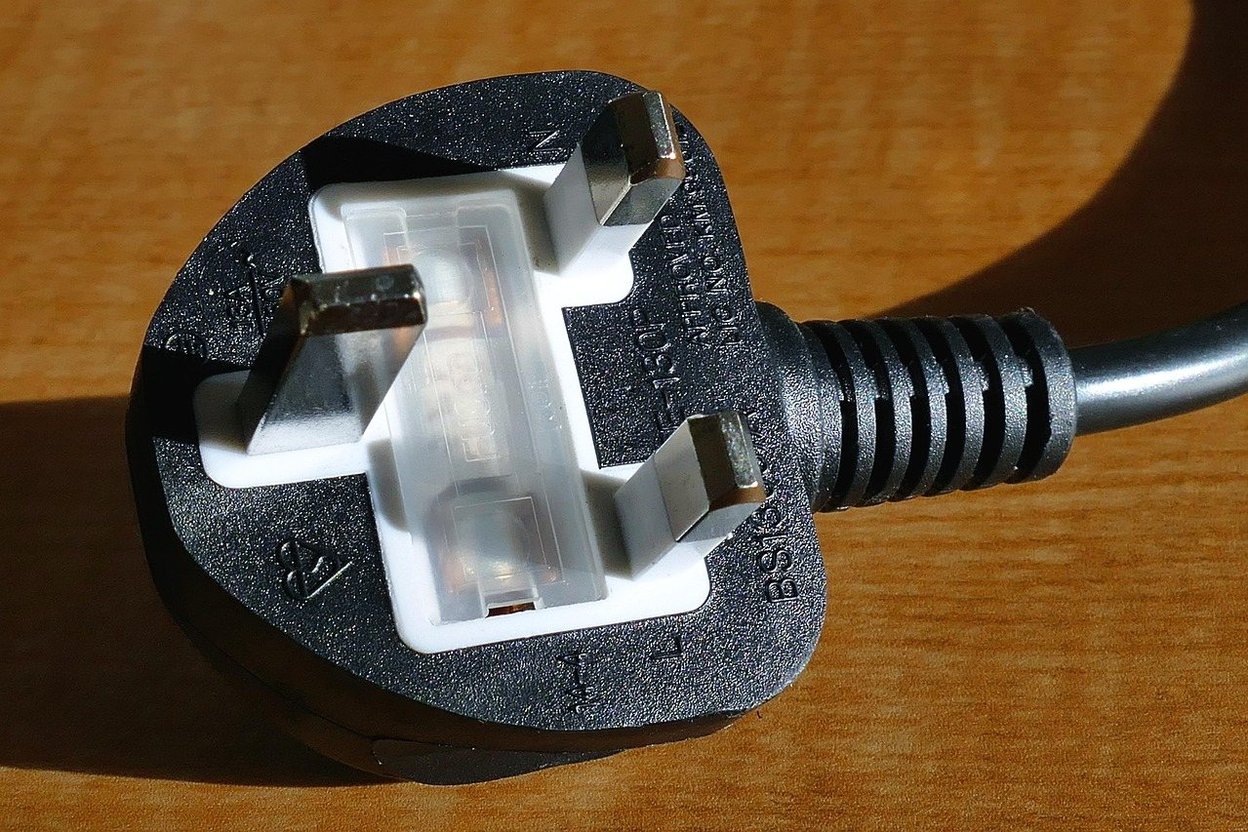 An RV power cord with an adapter plugged into a campground pedestal