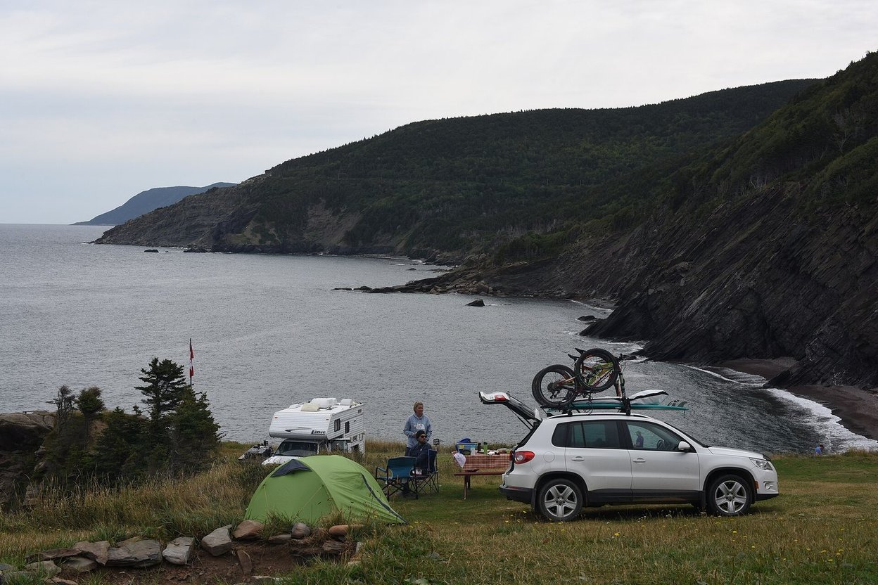 A car parked next to a tent at a campsite
