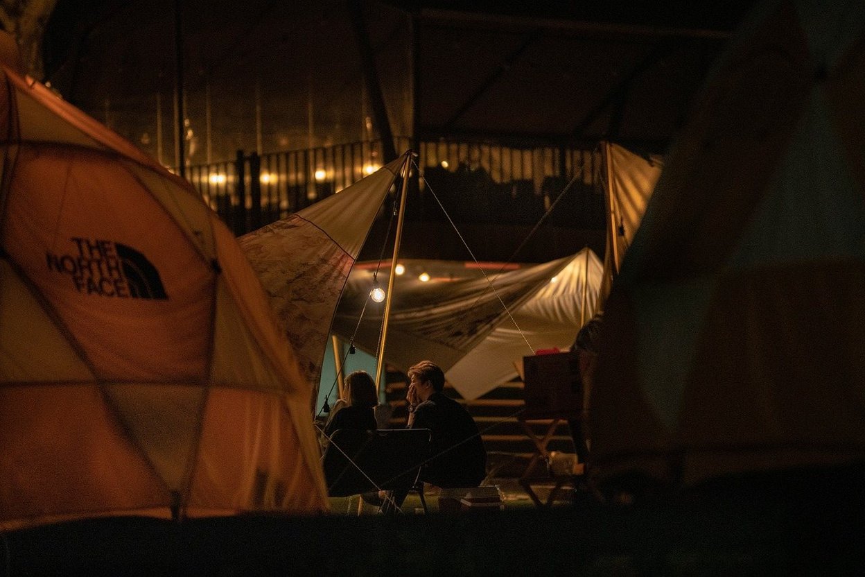A campsite Halloween display with orange string lights powered from the pedestal's household outlet
