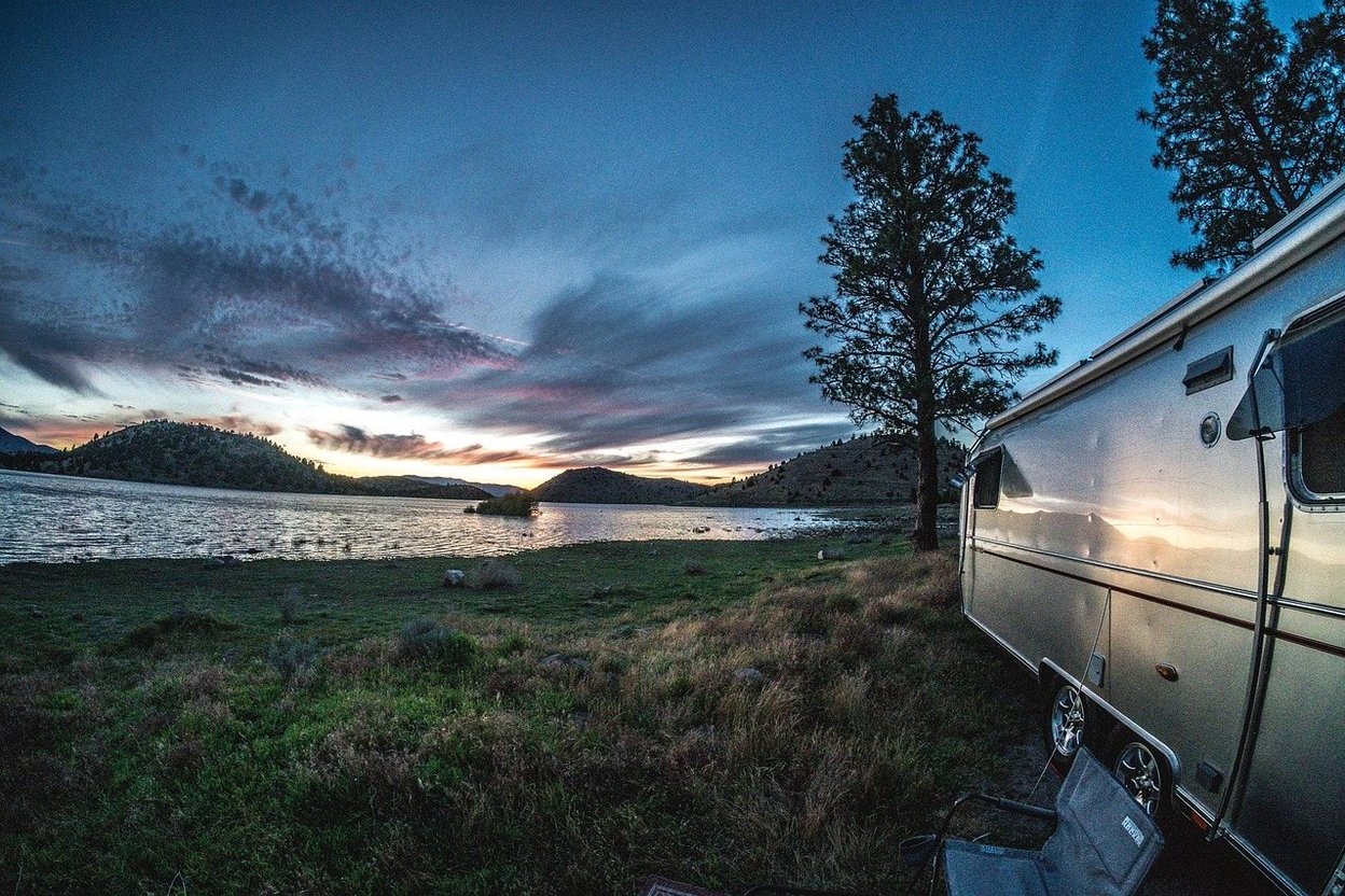 Water jugs lined up beside a camping trailer