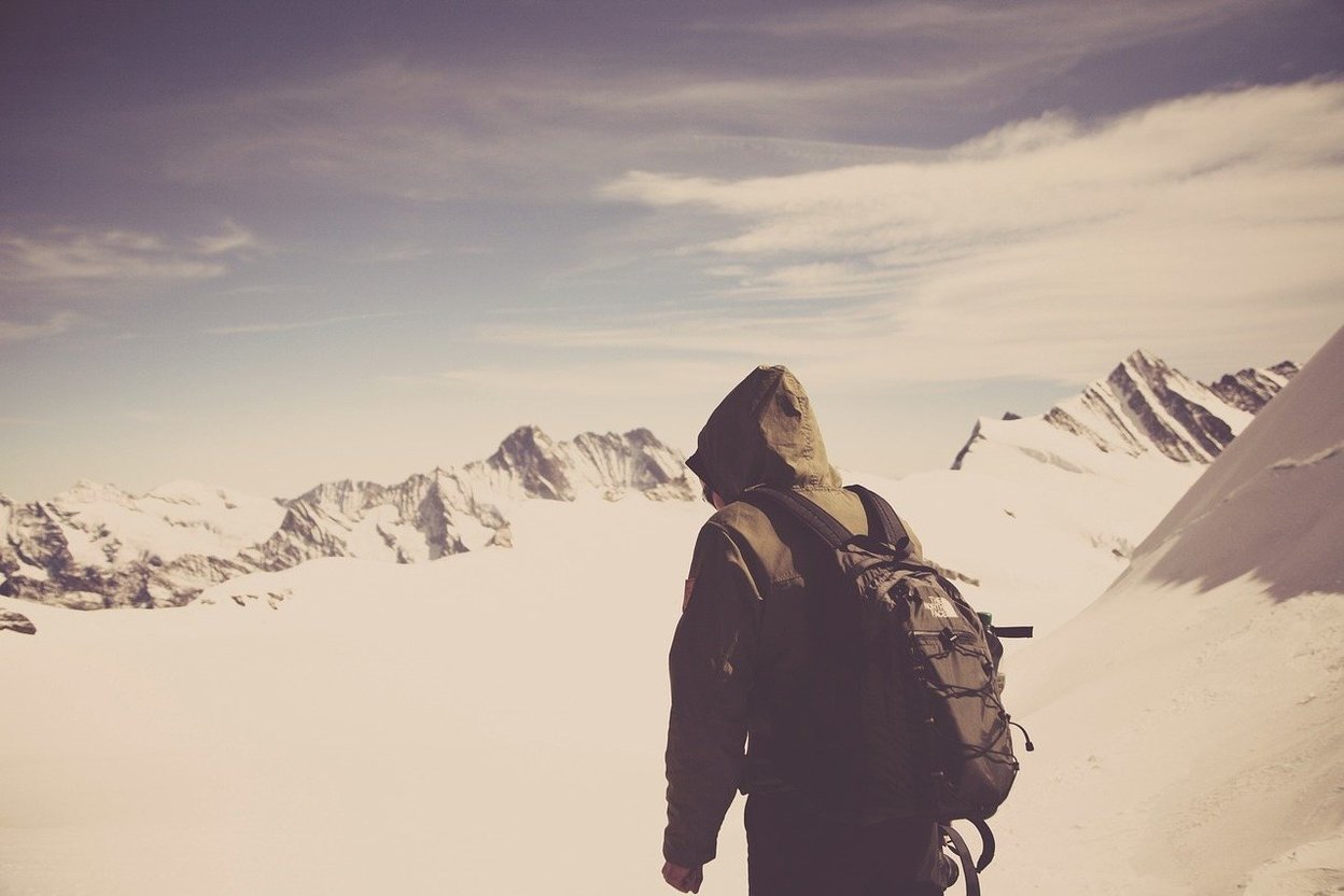 A hiker in a jacket with a backpack on a cool day outdoors
