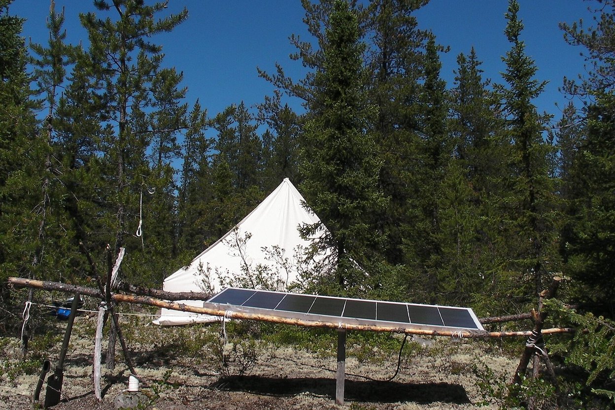 A portable power station with solar panel at a campsite